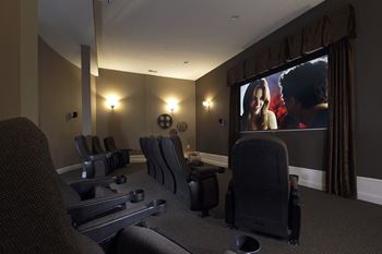 a screening room with chairs and a large screen tv
